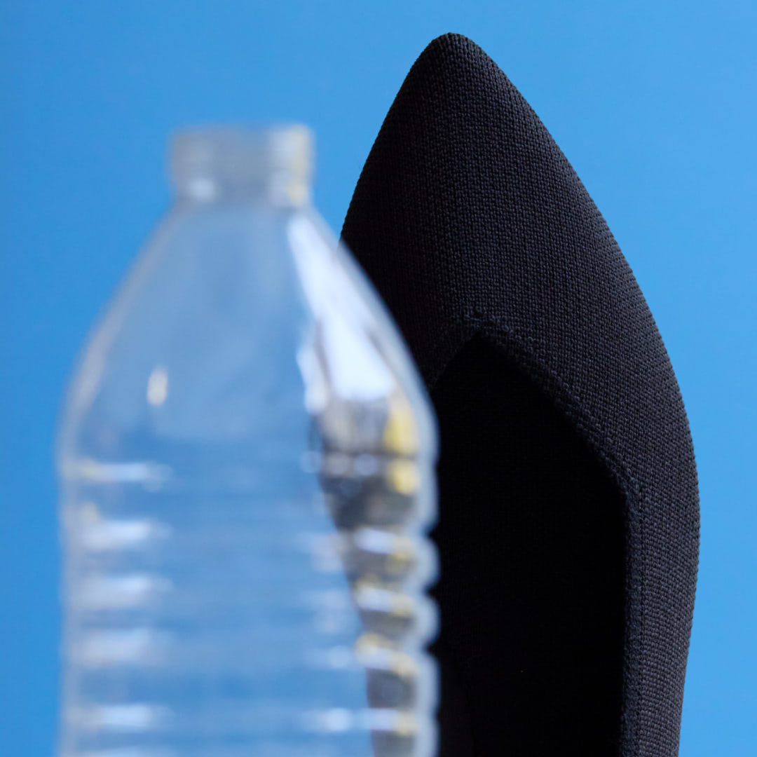 Image depicting plastic water bottle and The Point behind it.